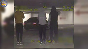 zdjęcie czarno-białe z monitoringu, grupa mężczyzn w podbliżu samochodu