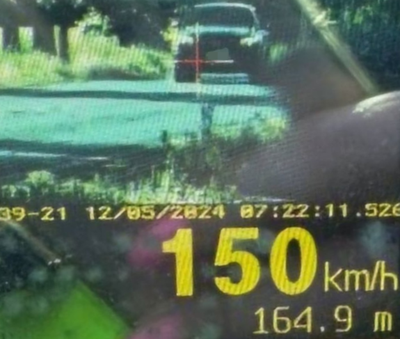 Zdjęcie z nagrania wideorejestratorem przedstawiające czarny samochód typu suv jadący z prędkością 150km/h.