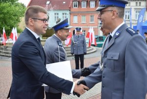 Burmistrz Sulęcina wraz z szefem sulęcińskiej Policji wręcza list gratulacyjny wyróżnionemu policjantowi.