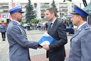 Burmistrz Lubniewic wraz z szefem sulęcińskiej Policji wręcza list gratulacyjny wyróżnionemu policjantowi.
