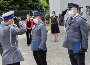 Komendant Powiatowy Policji w Sulęcinie podczas wręczenia awansu funkcjonariuszowi. Oboje wykonują gest oddania honoru.