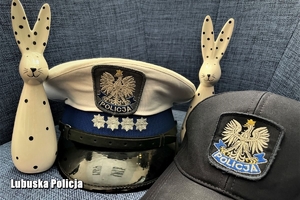 Policyjne czapki ruchu drogowego oraz prewencji. Między nimi dwie figurki wielkanocnych królików.