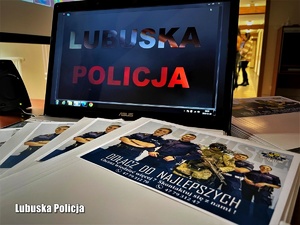 Ekran laptopa a na nim wyświetlony napis Lubuska Policja. Obok na stole leżą teczki wraz z ulotką promocyjną Dołącz do najlepszych.