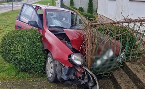 Pojazd po wypadku, wbity w przęsło ogrodzenia posesji.